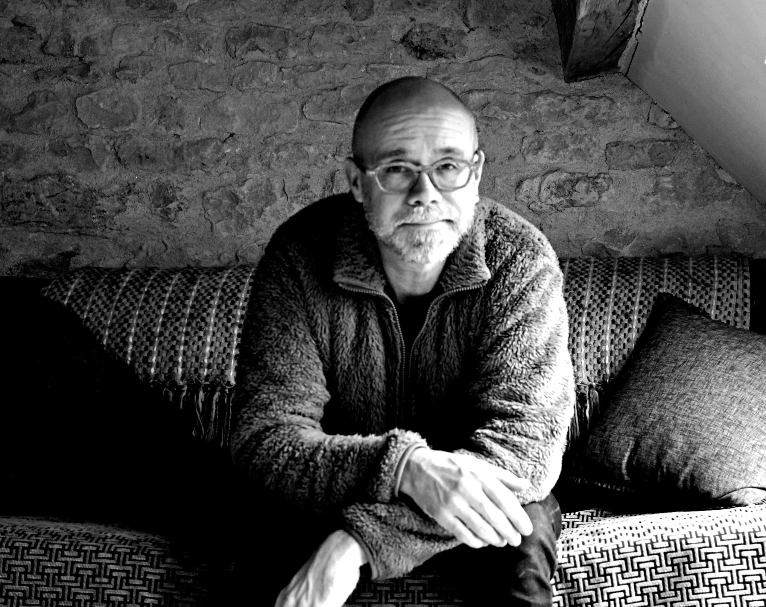 portrait-psychologue-jean-benoit-dumonteix-varzy Portrait en noir et blanc de Jean Benoit Dumonteix, psychologue clinicien à l'écoute, avec une barbe et des lunettes, assis sur un canapé, inspirant confiance et expertise.