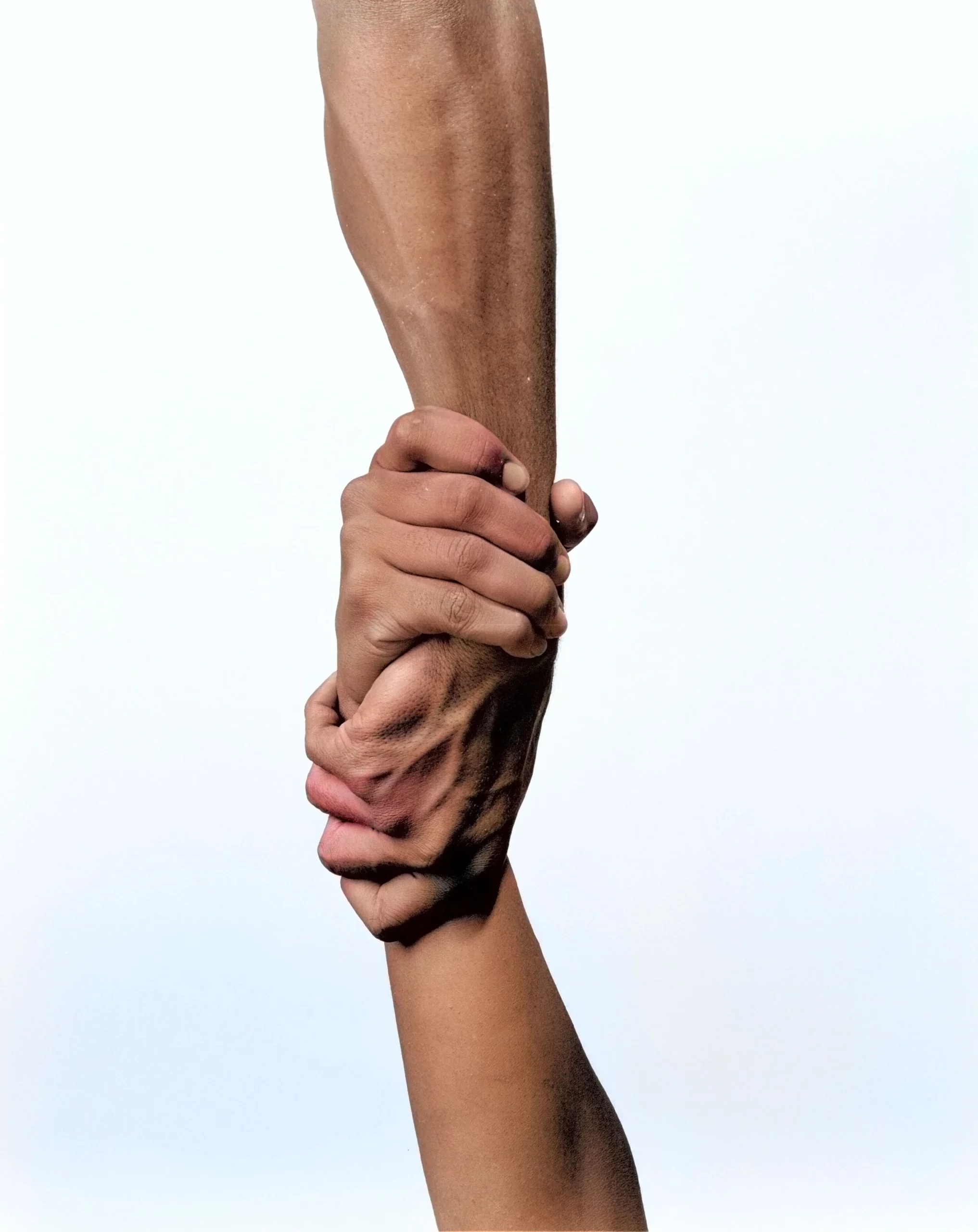 Deux mains se saisissant fermement l'une l'autre, symbolisant le soutien, l'aide mutuelle et l'accompagnement en psychologie.