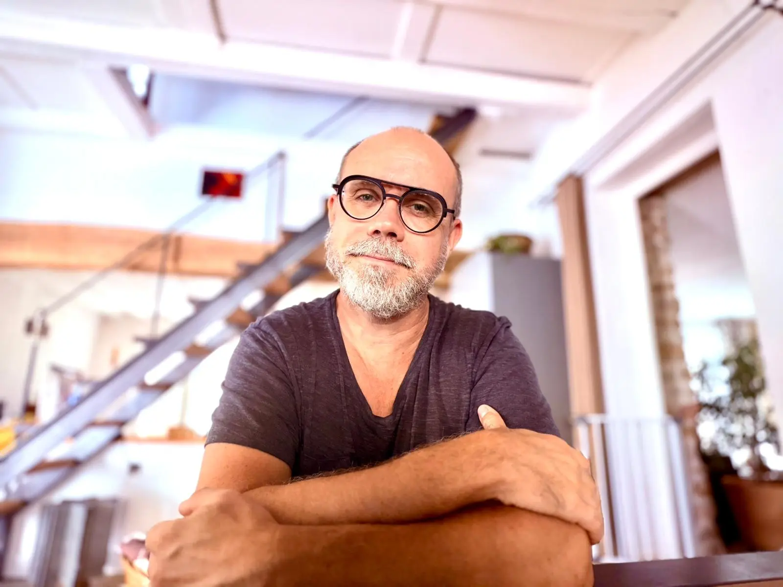 Portrait en noir et blanc de Jean Benoit Dumonteix, psychologue clinicien à l'écoute, avec une barbe et des lunettes, assis sur un canapé, inspirant confiance et expertise.